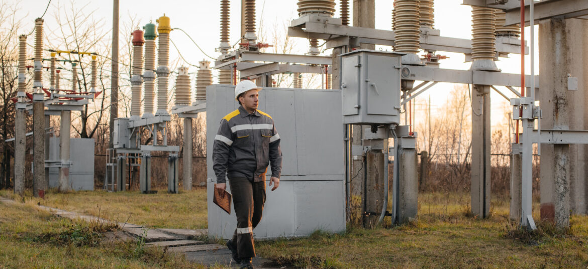 Energy engineer inspects substation power equipment